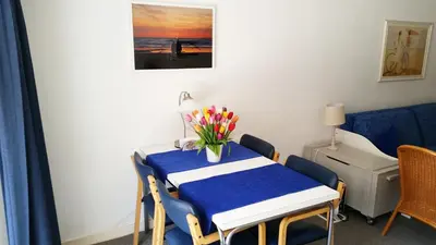 a room with a table with a vase of flowers on it at Appartement in Zandvoort in Zandvoort