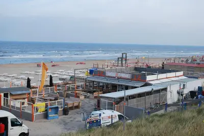 a beach with buildings and a beach with the ocean at Appartement in Zandvoort in Zandvoort