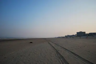 an empty beach with tracks in the sand at Appartement in Zandvoort in Zandvoort
