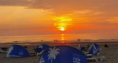 a group of tents on the beach at sunset at Santvort Luxury Apartment with Private Parking in Zandvoort