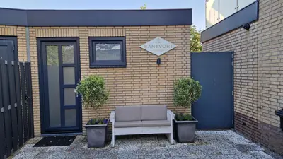 a couch sitting in front of a brick building at Santvort Luxury Apartment with Private Parking in Zandvoort