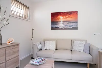 a living room with a couch and a table at Santvort Luxury Apartment with Private Parking in Zandvoort