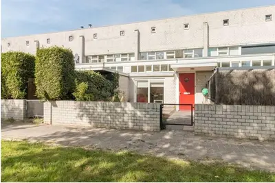 a large white building with a red door at Family house next to train and close to Amsterdam and Schiphol in Almere