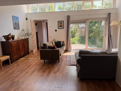 a living room with two couches and a large window at Family house next to train and close to Amsterdam and Schiphol in Almere
