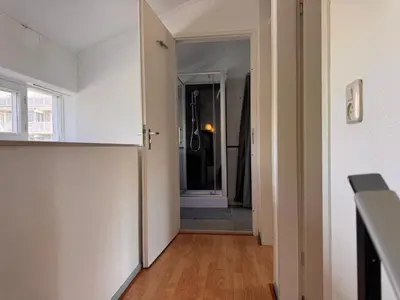 a hallway with a door leading to a bathroom at Family house next to train and close to Amsterdam and Schiphol in Almere