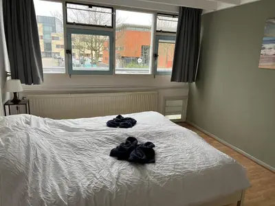 a bedroom with two pairs of gloves on a bed at Family house next to train and close to Amsterdam and Schiphol in Almere