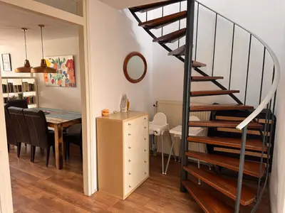 a kitchen and dining room with a spiral staircase at Family house next to train and close to Amsterdam and Schiphol in Almere