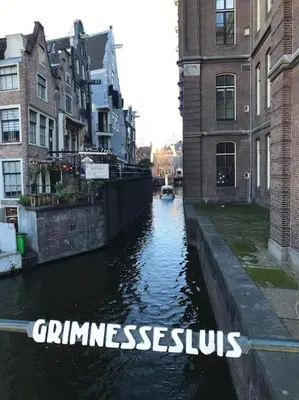 a canal in a city with a boat in the water at Family house next to train and close to Amsterdam and Schiphol in Almere