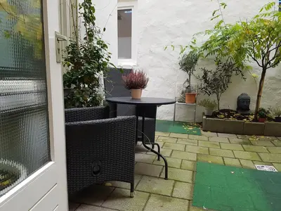 a small black table in a courtyard with plants at B&B Wladimir Studios in Amsterdam