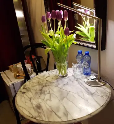 a marble table with a vase of flowers on it at B&B Wladimir Studios in Amsterdam