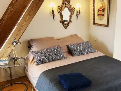 a bedroom with a bed with pillows and a mirror at Canal View B&B Amsterdam in Amsterdam