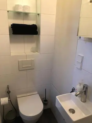 a white bathroom with a toilet and a sink at Canal View B&B Amsterdam in Amsterdam