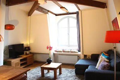 a living room with a blue couch and a window at Amsterdam Jewel Canal Apartments in Amsterdam
