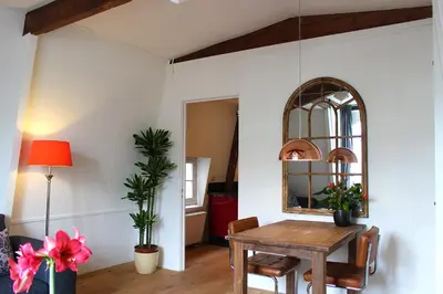 a dining room with a table and a mirror at Amsterdam Jewel Canal Apartments in Amsterdam