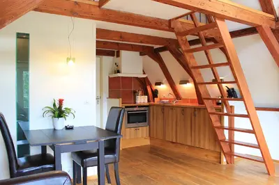 a kitchen with a dining room table and a ladder at Amsterdam Jewel Canal Apartments in Amsterdam