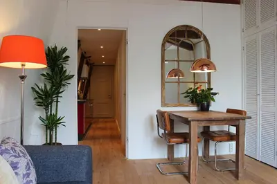 a living room with a table and a mirror at Amsterdam Jewel Canal Apartments in Amsterdam