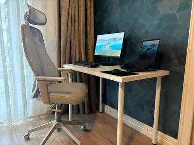 a desk with a computer and a laptop on it at The Cosy Cottage for Comfort with Sauna and Hottub in Zeewolde