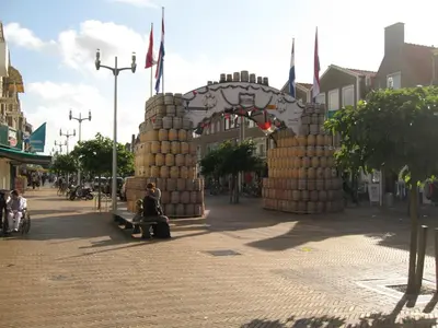 a person sitting on a bench in front of a gate at Bed&Breakfast aan Strand in Katwijk aan Zee