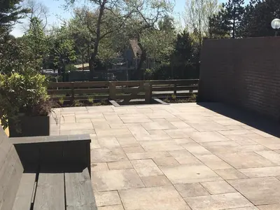 a patio with a bench and a wooden fence at Amsterdam Beach Home 4 in Zandvoort