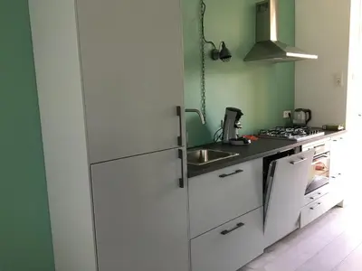 a kitchen with a white refrigerator and a sink at Amsterdam Beach Home 4 in Zandvoort