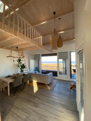 a living room with a couch and a table at Eb en Vloed Katwijk in Katwijk