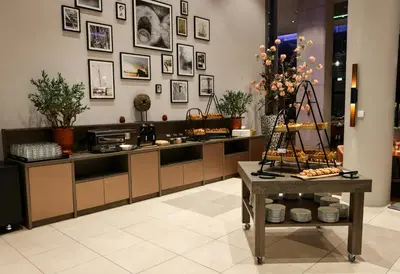 a kitchen with a counter with pictures on the wall at Leonardo Royal Hotel Amsterdam in Amsterdam