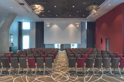 a lecture hall with chairs and a projection screen at Leonardo Royal Hotel Amsterdam in Amsterdam