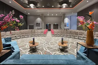 a conference room with chairs and tables and flowers at Leonardo Royal Hotel Amsterdam in Amsterdam