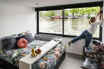 a girl jumping out of a window in a room at Houseboat Amsterdam - Room with a view in Amsterdam
