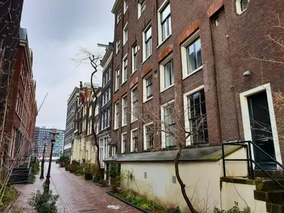 an empty city street with tall brick buildings at Houseboat Amsterdam - Room with a view in Amsterdam