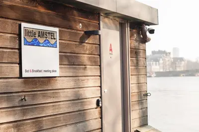 a sign on the side of a building with a door at Houseboat Little Amstel in Amsterdam