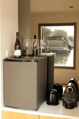 two glasses of wine sitting on top of a refrigerator at Houseboat Little Amstel in Amsterdam