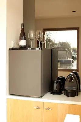 a refrigerator with two wine glasses on top of it at Houseboat Little Amstel in Amsterdam