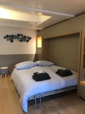 a bedroom with a bed with two black towels on it at Singel Residence in Amsterdam