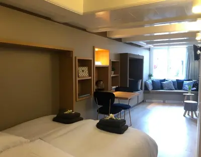 a bedroom with a bed and a table and a couch at Singel Residence in Amsterdam