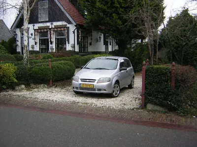 a small silver car parked in front of a house at Prive tuinhuis B&B Elly in Sint Pancras
