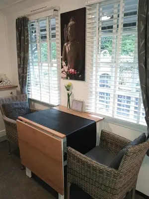 a desk in a room with two chairs and a painting at Prive tuinhuis B&B Elly in Sint Pancras