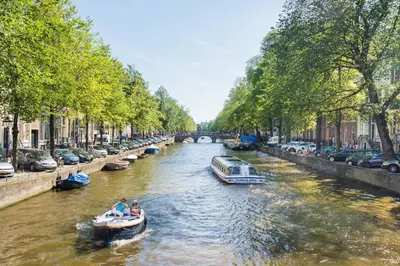 two people in a boat on a river with cars at Studio Koggeschip in Amsterdam