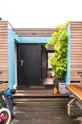 a house with a black door on a wooden porch at Houseboat Ark van Amstel in Amsterdam