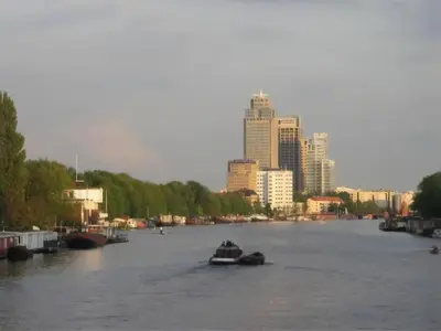 a boat on a river with a city in the background at Houseboat Ark van Amstel in Amsterdam
