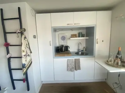 a kitchen with white cabinets and a sink at Houseboat Ark van Amstel in Amsterdam
