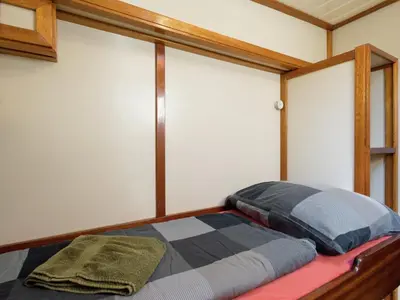 a bed with two pillows on it in a room at Boat in Leiden near City Center & Museums in Leiden