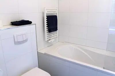 a white bathroom with a tub and a toilet at B&B Utrecht Domkwartier in Utrecht