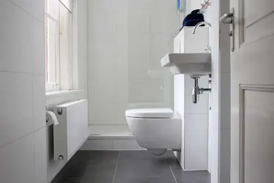 a white bathroom with a toilet and a sink at B&B Utrecht Domkwartier in Utrecht