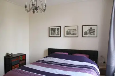 a bedroom with a bed with three pictures on the wall at B&B Utrecht Domkwartier in Utrecht
