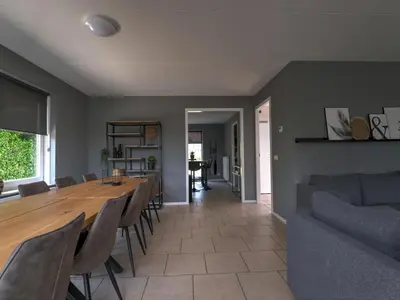 a dining room and living room with a table and chairs at Villa in Zeewolde near Horsterwold Forest in Zeewolde