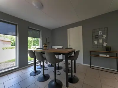 a dining room with a wooden table and chairs at Villa in Zeewolde near Horsterwold Forest in Zeewolde