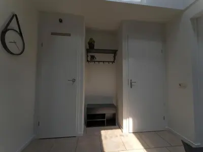 an empty hallway with a door and a mirror at Villa in Zeewolde near Horsterwold Forest in Zeewolde
