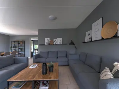 a living room with a couch and a table at Villa in Zeewolde near Horsterwold Forest in Zeewolde