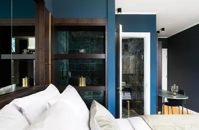 a bedroom with blue walls and a bed with white pillows at Spinoza Suites in Amsterdam